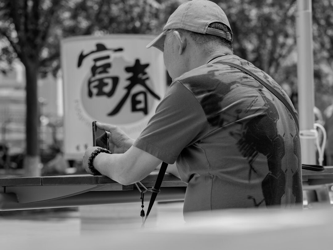 Elderly Japanese man practicing calligraphy with brush and ink