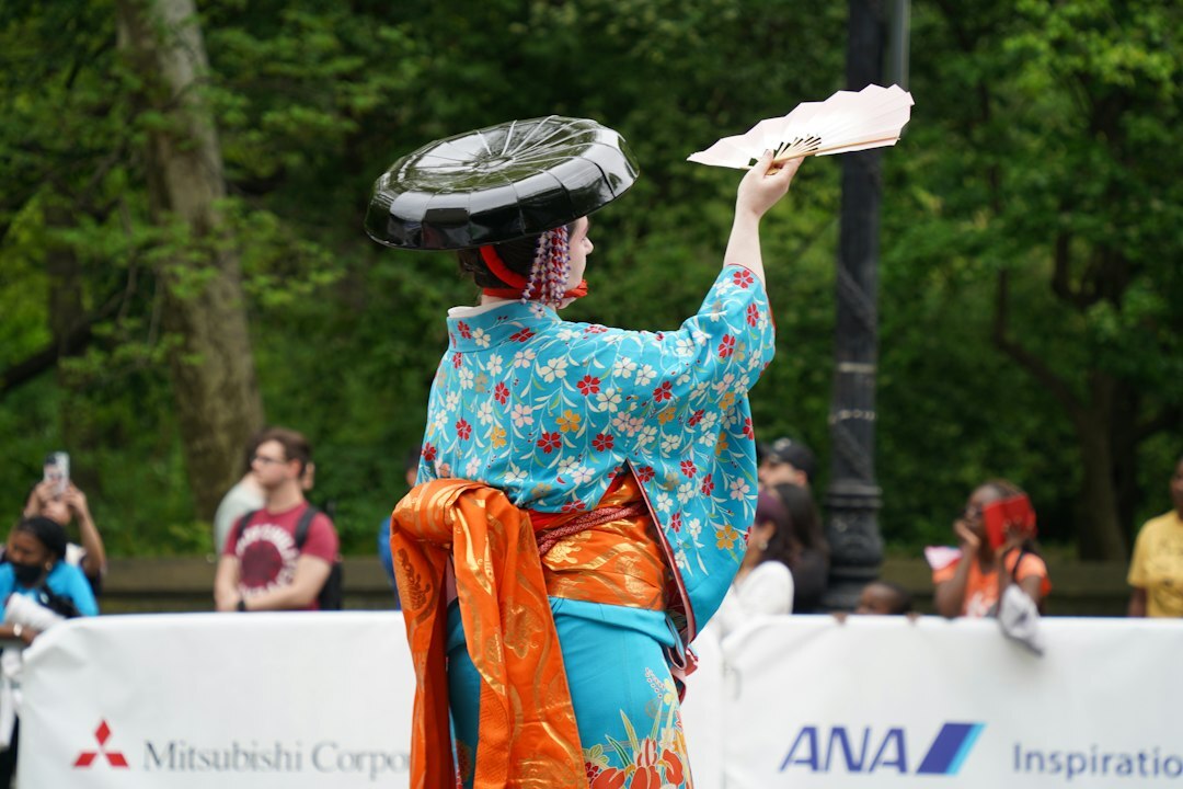 Elderly Japanese woman in kimono dancing a traditional folk dance at a festival